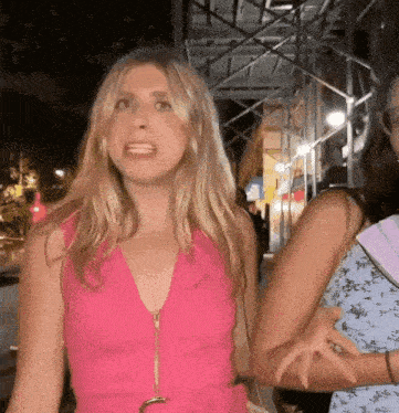 a woman in a pink dress is standing next to another woman in a blue dress