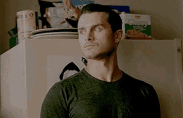 a man standing in front of a fridge with a box of chewy cereal