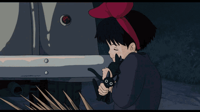 a girl with a red headband is holding a black cat in front of a car