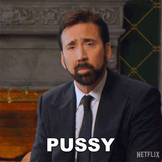 a man in a suit and tie has the word pussy on his chest