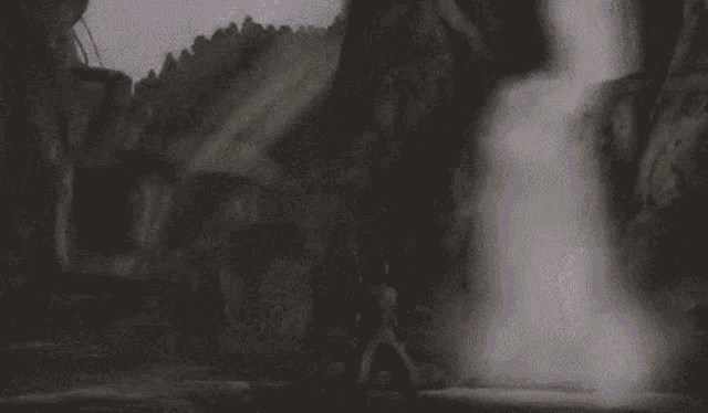 a man is standing in front of a waterfall