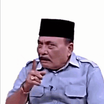 a man wearing a hat and a blue shirt is pointing his finger at something .