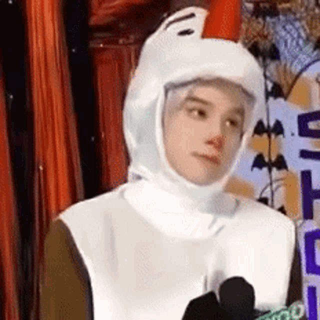 a man in a chicken costume is standing in front of a sign that says halloween .
