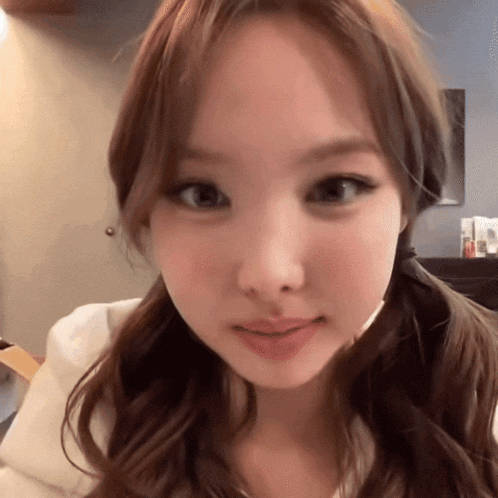 a close up of a woman 's face with pigtails looking at the camera .