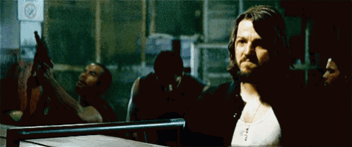 a man with long hair and a beard is standing in front of a no smoking sign