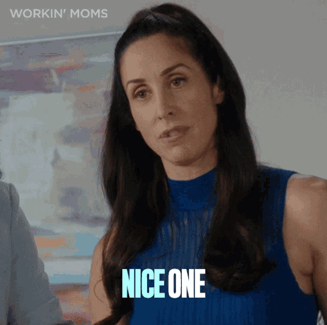 a woman is wearing a blue top and says nice one