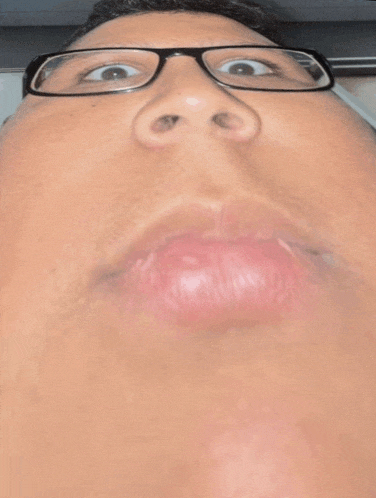 a close up of a man wearing glasses and making a funny face