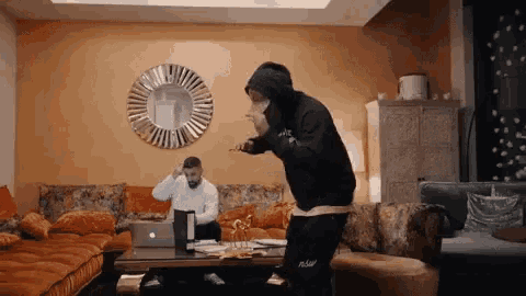 a man in a black nike hoodie stands in front of a laptop