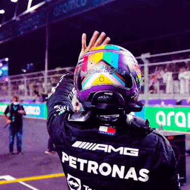 a man wearing a helmet and a shirt that says petronas on it