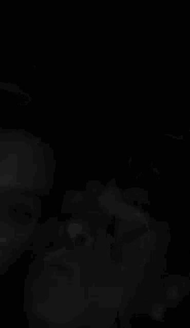 a close up of a person 's face in a dark room