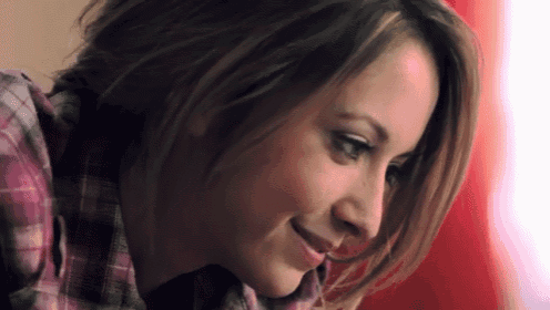 a close up of a woman 's face with a plaid shirt