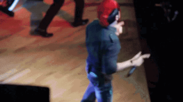 a man wearing a red hat is holding a microphone