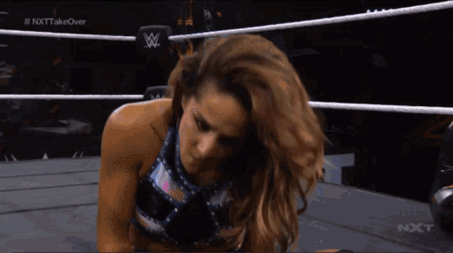 a woman in a wrestling ring with the hashtag nxt takeover