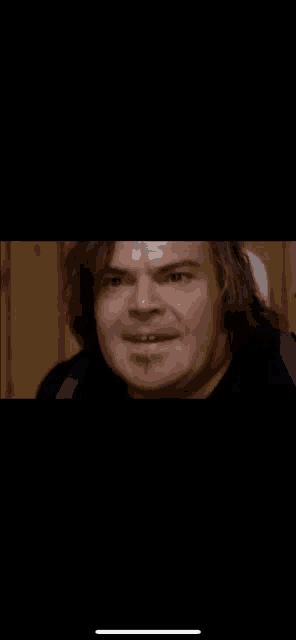 a man with long hair and a beard is making a face