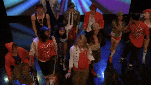 a group of people are dancing with one wearing a red shirt that says " love "