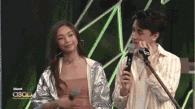 a man is holding a microphone while a woman stands behind him