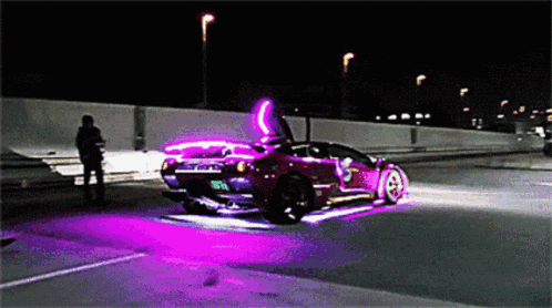 a car with purple lights on it is driving down the road