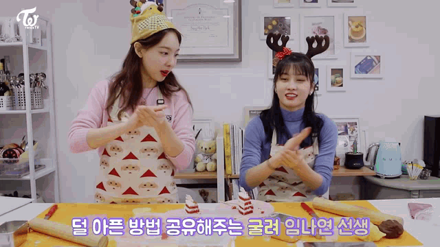 two women wearing aprons and reindeer antlers are standing next to each other