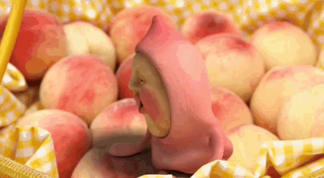 a basket filled with peaches and a pink figurine of a gnome .