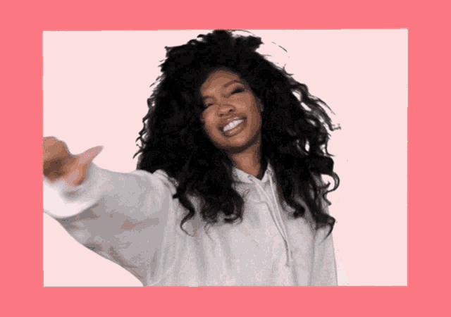 a woman with curly hair wearing a white hoodie