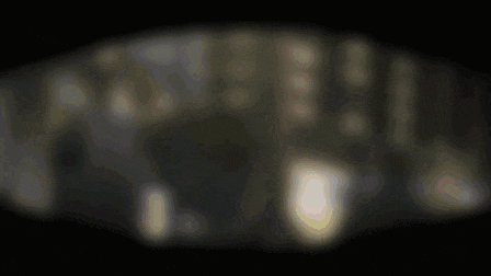 a blurred image of a dark room with a few lights on