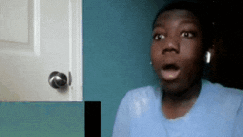 a young man with a surprised look on his face is wearing headphones