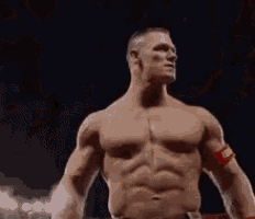 a man without a shirt is standing in a ring with his arms outstretched .