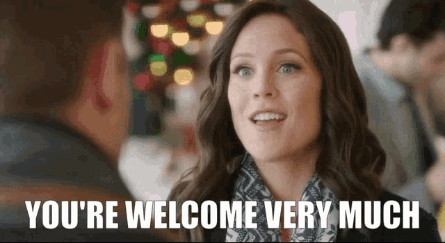 a woman says " you 're welcome very much " while smiling