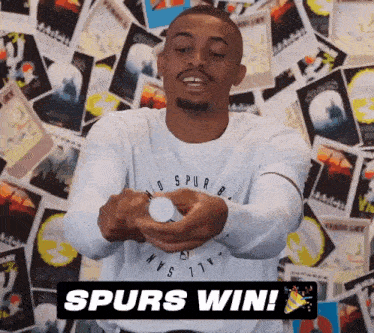 a man wearing a spurs shirt is holding a bottle in his hands