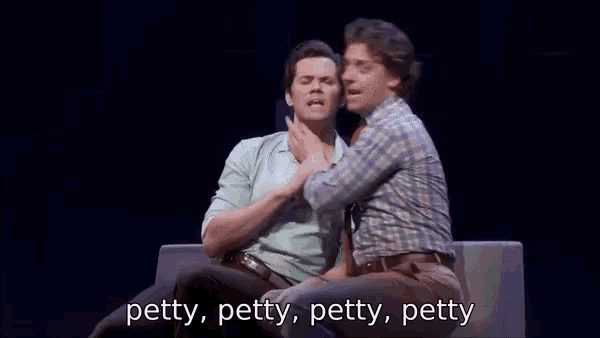 a couple of men are sitting next to each other on a stage .