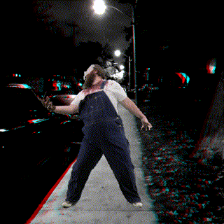 a man wearing overalls and a mask is walking down a sidewalk