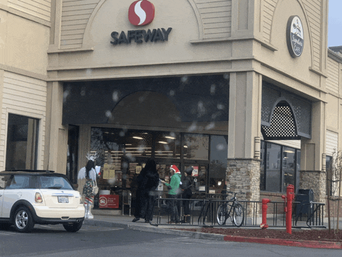 a white mini cooper is parked outside of a safeway