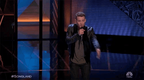 a man singing into a microphone with the hashtag #songland