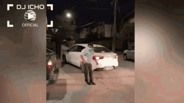 a man in a mask stands in front of a white car with dj icho official written on the bottom