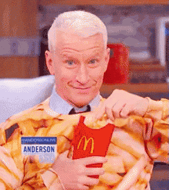 a man with a name tag that says anderson is holding a mcdonalds french fry