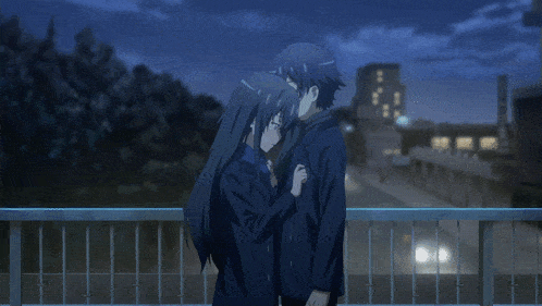 a man and a woman are hugging each other on a bridge