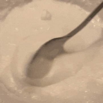 a spoon is being used to stir a white liquid