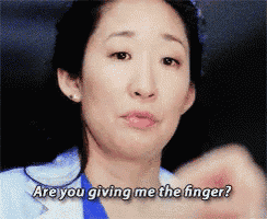 a woman in a blue shirt is saying " are you giving me the finger ? "