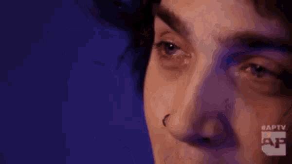 a close up of a person 's face with their eyes closed and a nose ring .