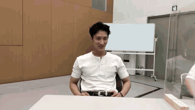 a man in a white shirt is sitting at a table