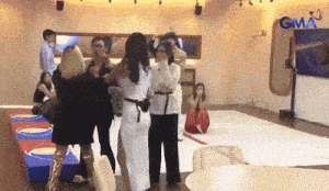 a group of people are standing in a room with a sign that says gma on it