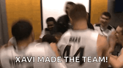 a group of basketball players are hugging each other in a locker room and they are celebrating .