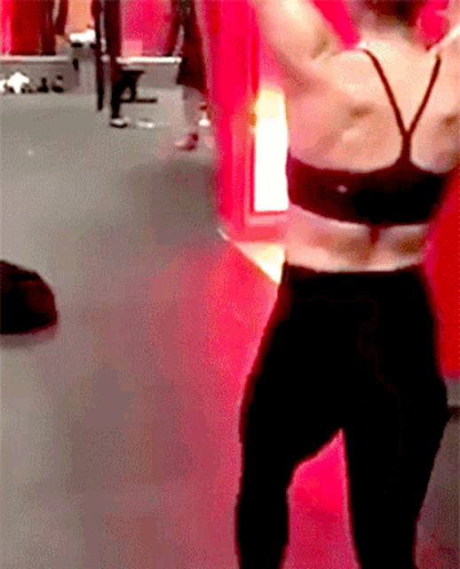 a woman in a black bra and black pants is dancing