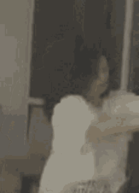 a woman is talking on a cell phone while waving her hand .