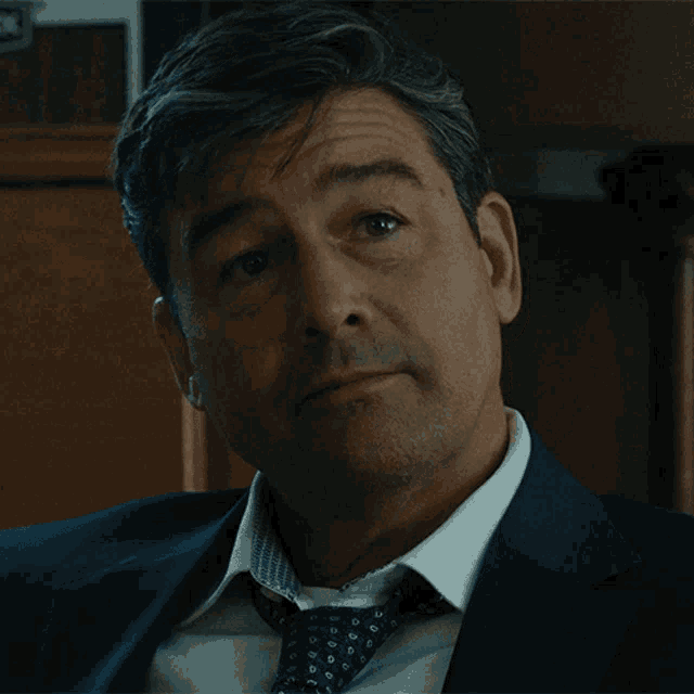a man in a suit and tie looks down