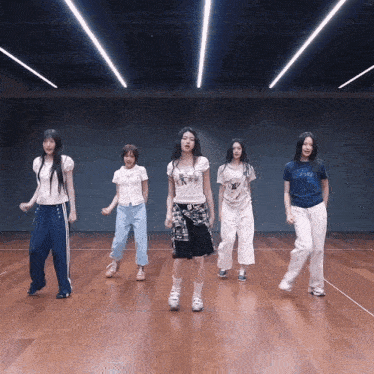 a group of girls are dancing in a room and one of them is wearing a shirt that says ' snoopy '
