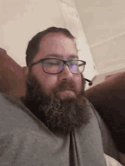 a man with a beard wearing glasses and a microphone