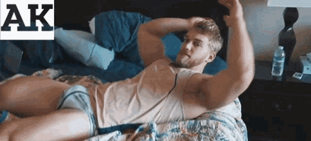 a man in underwear is laying on a bed and taking a picture of himself