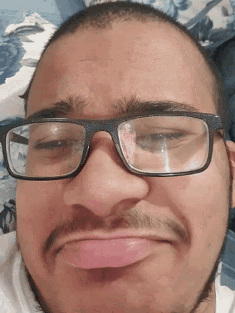 a man with glasses and a beard making a face