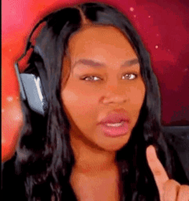a woman wearing headphones is giving a thumbs up sign